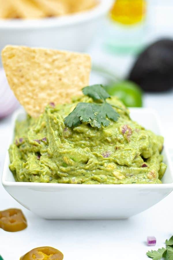 guacamole in a serving tray with chip in it