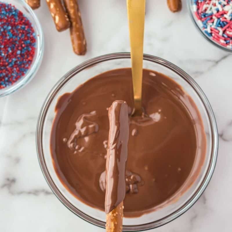 dipping pretzel rod in chocolate