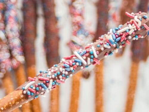 holding a 4th of july pretzel rod in hand