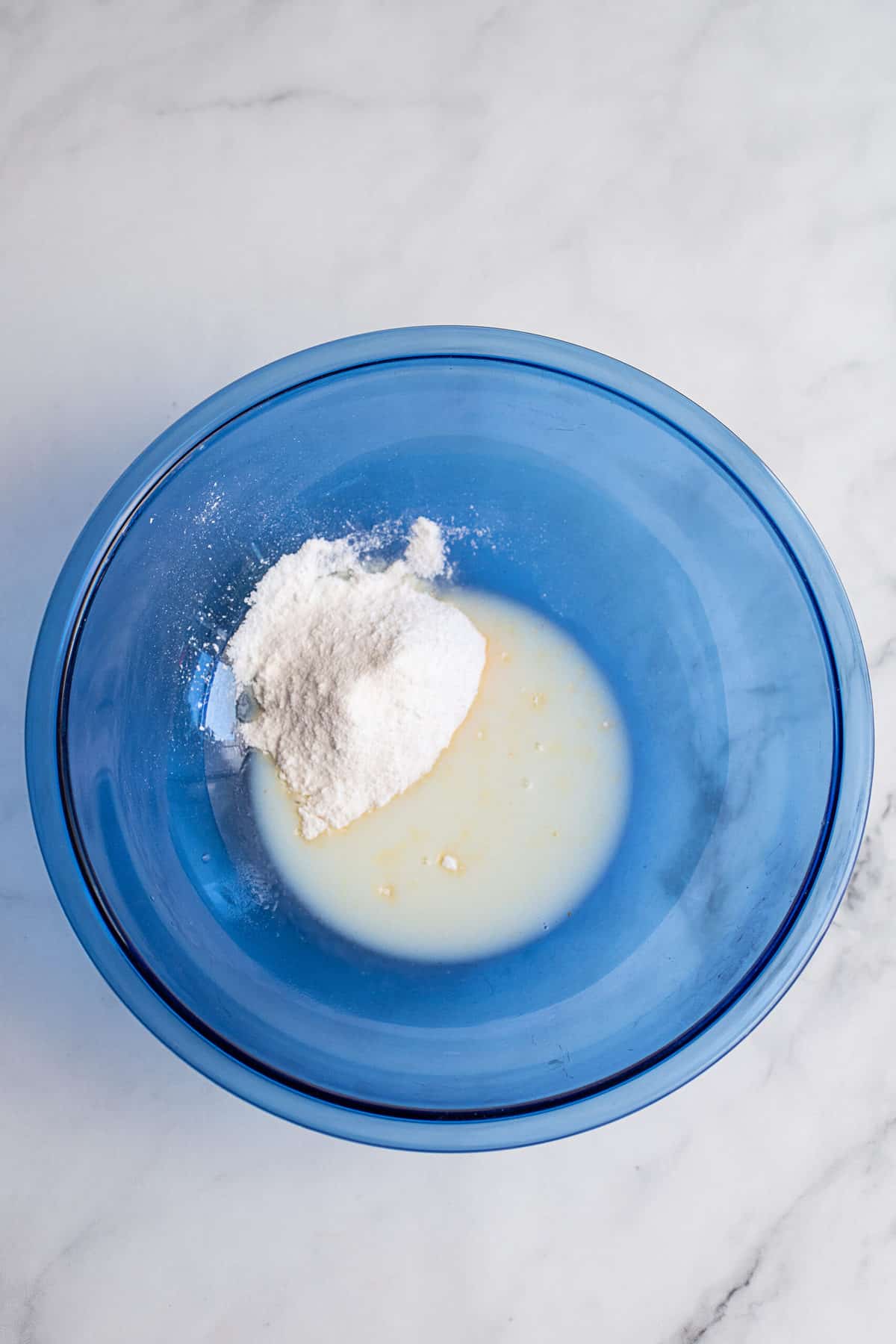 Milk and pudding in blue mixing bowl