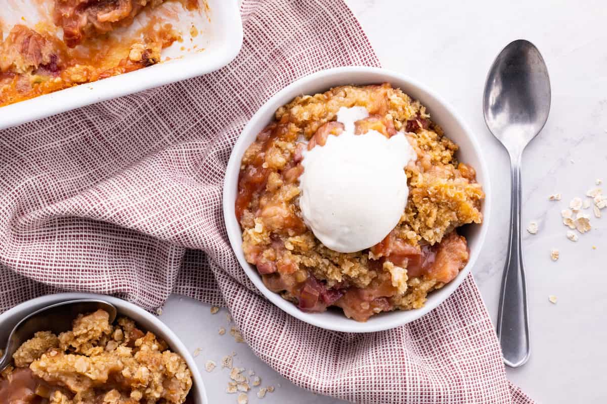 Rhubarb crisp topped with scoop of vanilla ice cream.