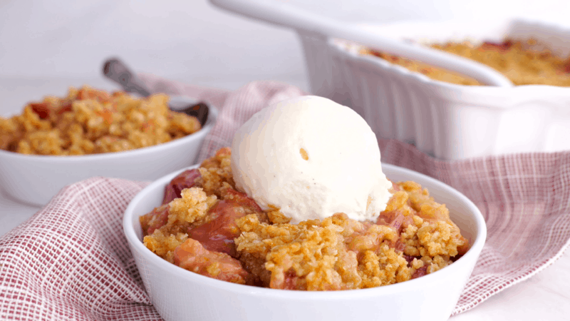 Rhubarb crisp topped with scoop of vanilla ice cream.