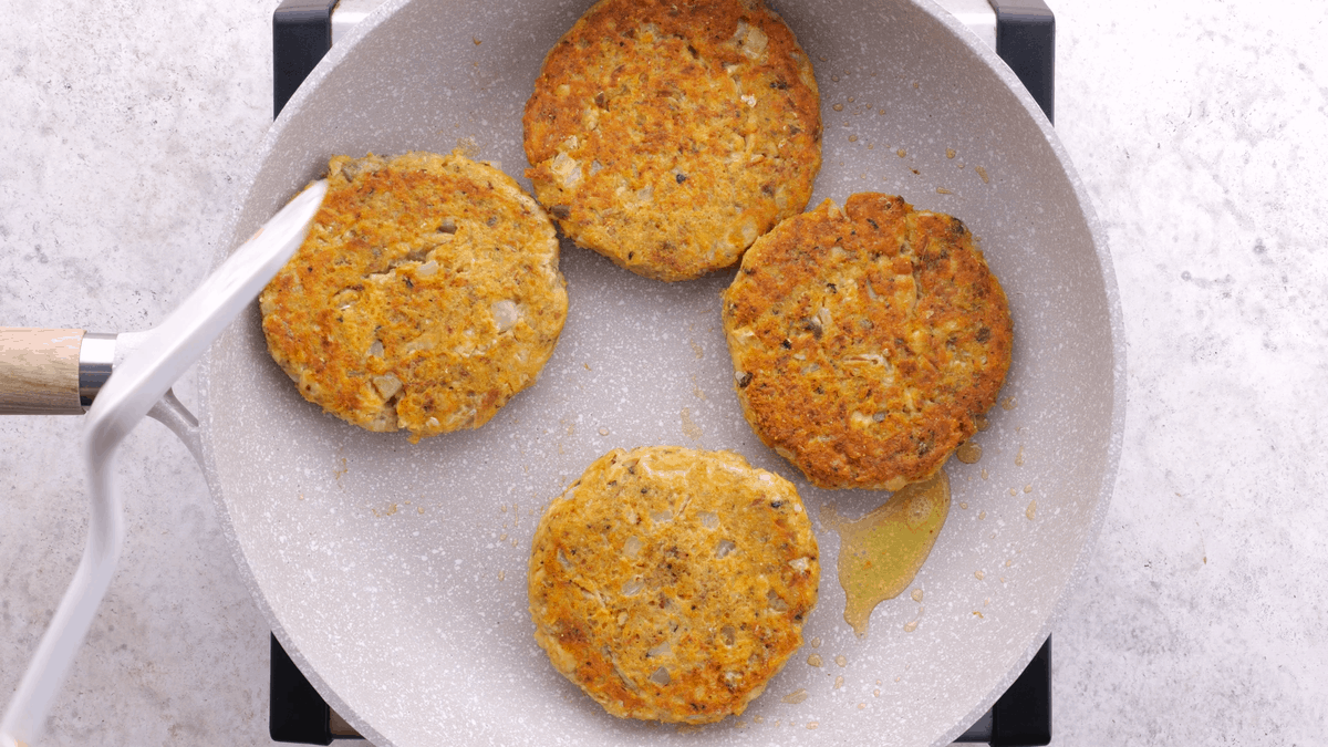 Golden brown salmon patties in skillet.