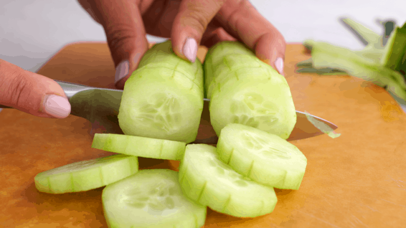Cutting peeled cucumbers.