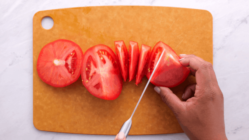 Cutting tomato into chunks.