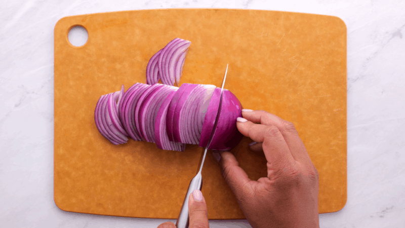 Cutting onion into large chunks.