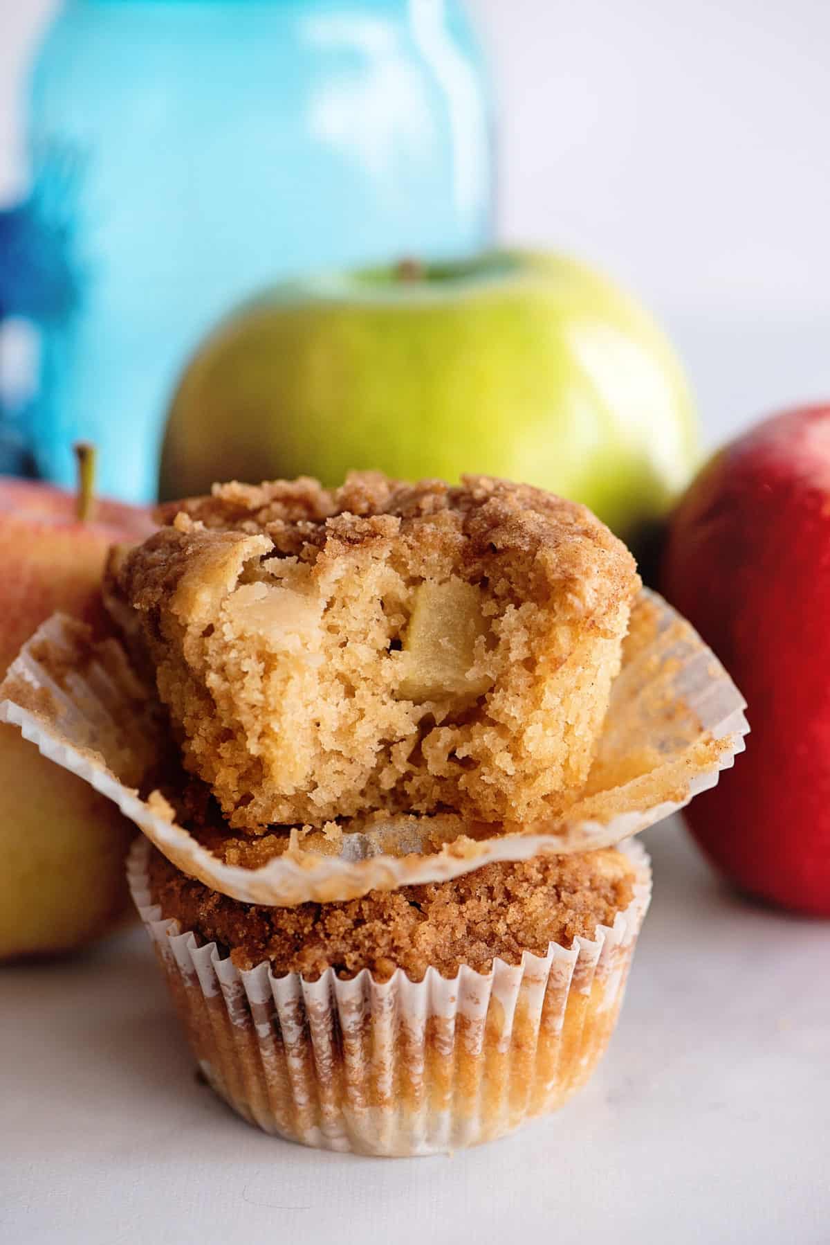 Two stacked apple muffins, with bite out of top muffin.