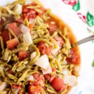 A bowl of green beans and tomatoes.