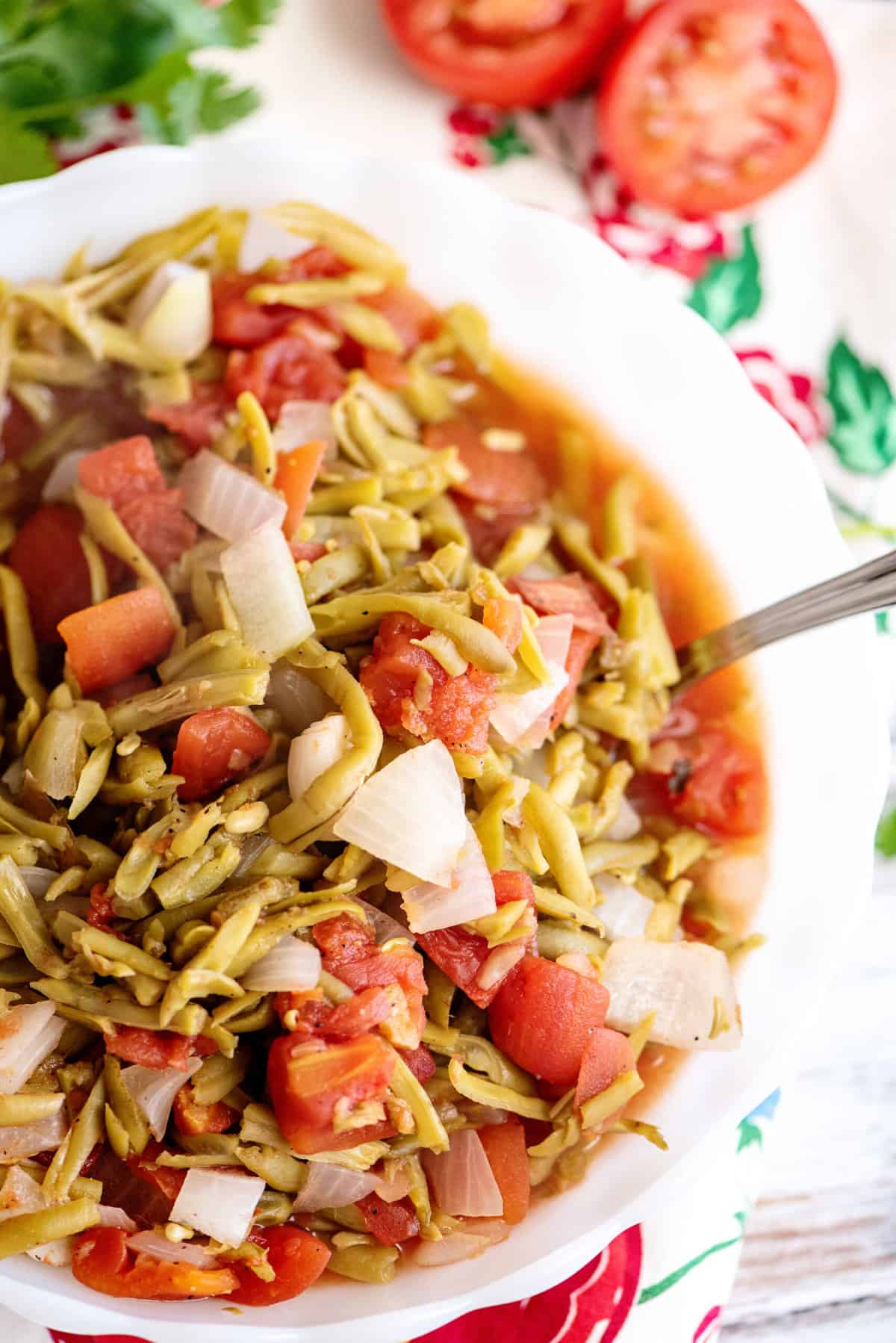 A bowl of green beans and tomatoes.
