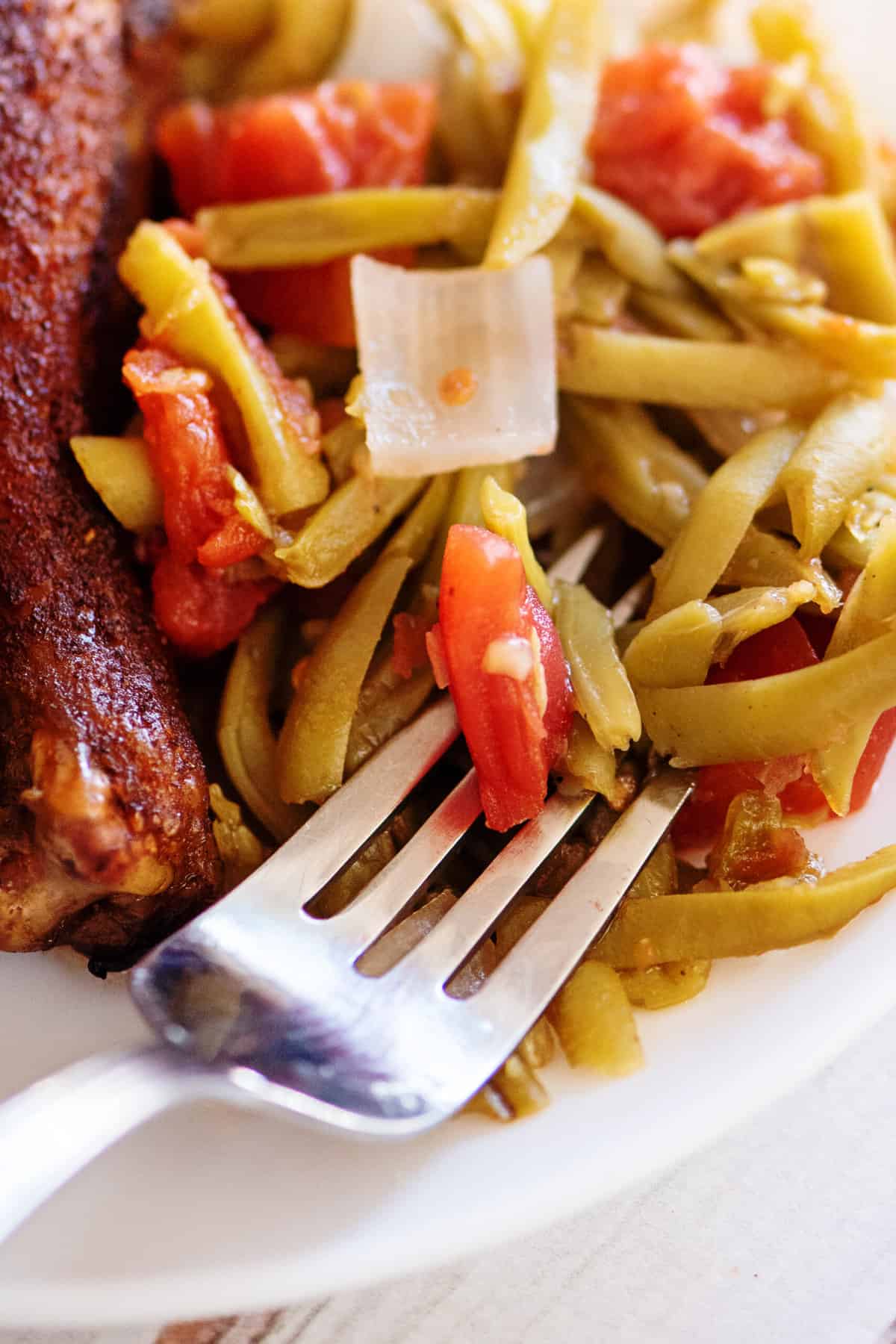 A close-up of green beans and tomatoes.