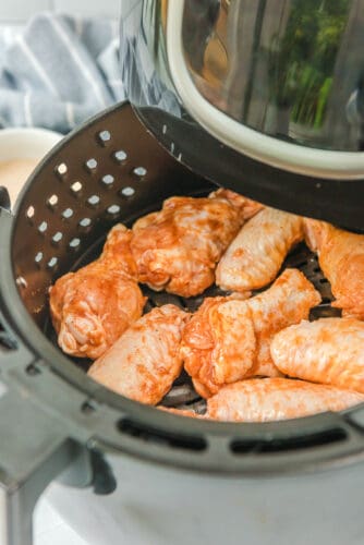 Chicken wings in air fryer basket.