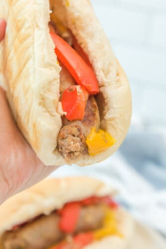 Close-up of sausage and peppers in hoagie bun.