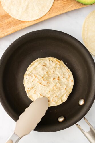 Toast corn tortilla in skillet.