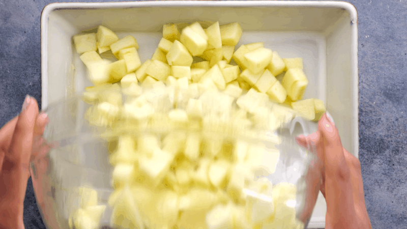 Placing chopped apples in baking dish.