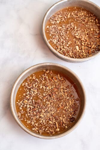 Sprinkle praline in cake pans with pecans.