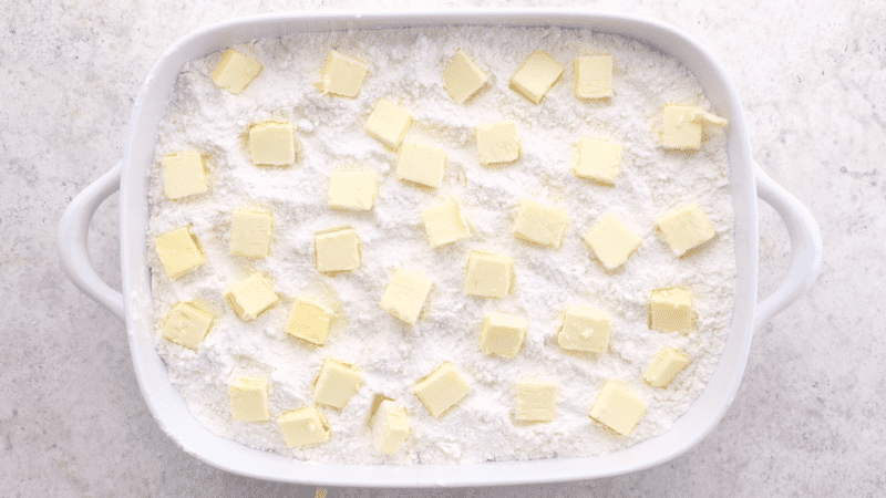 Place butter pieces evenly over cake mix in baking dish.