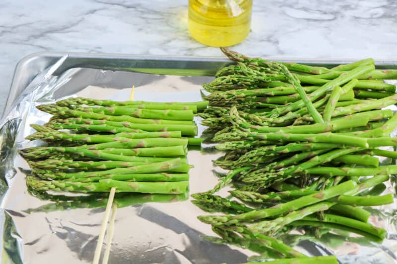 Threading asparagus onto bamboo skewers.
