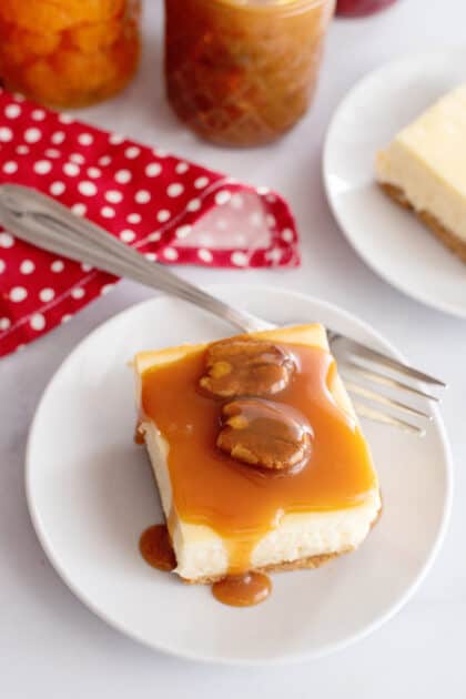 Slice of cheesecake with pecan praline sauce.