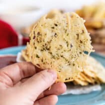 Hand holding up a parmesan crisp.