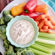 Chipotle ranch dressing surrounded by vegetables on serving plate.