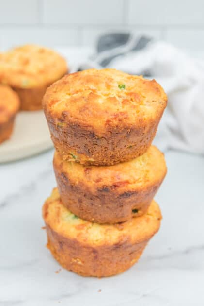 3 Jalapeño cornbread muffins stacked on top of one another.