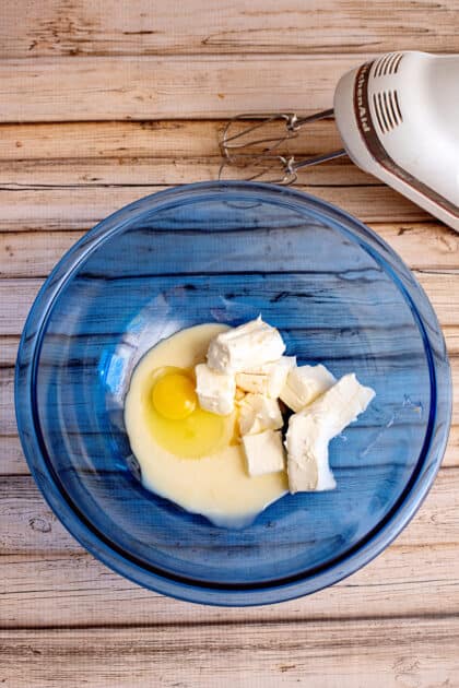 In a large bowl, place the softened cream cheese, condensed milk, egg, and vanilla extract.