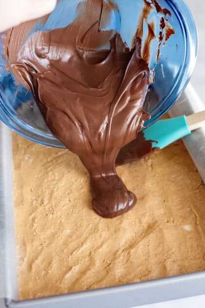 Pour melted chocolate over peanut butter mixture in pan.