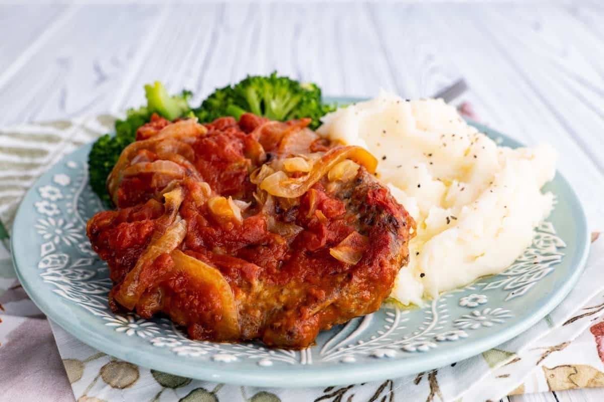 Serve swiss steak in oven with steamed vegetables and mashed potato.