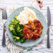 Swiss steak on plate with mashed potato and veggies.