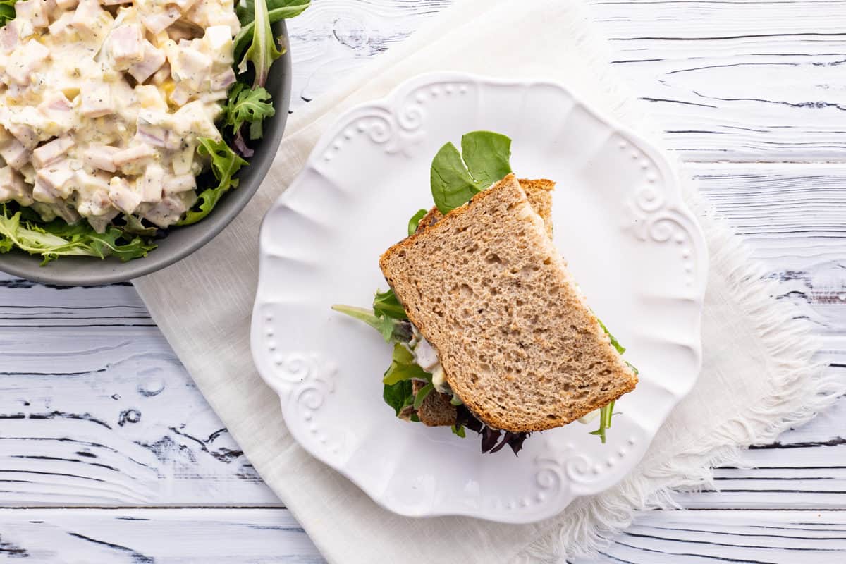 Old-fashioned ham salad sandwich on a decorative white plate.