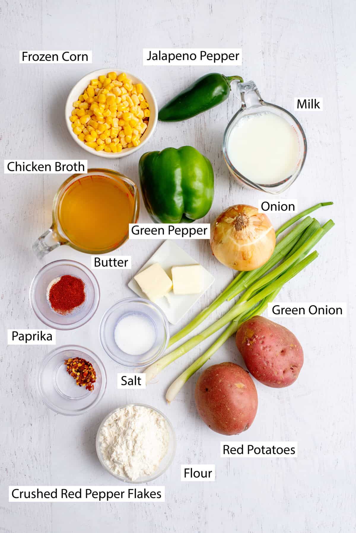 Ingredients for potato corn chowder, featuring butter, onion, green bell pepper, chicken broth, red potatoes, jalapenos, paprika, salt, red pepper flakes, frozen corn, milk, green onions, and all-purpose flour.