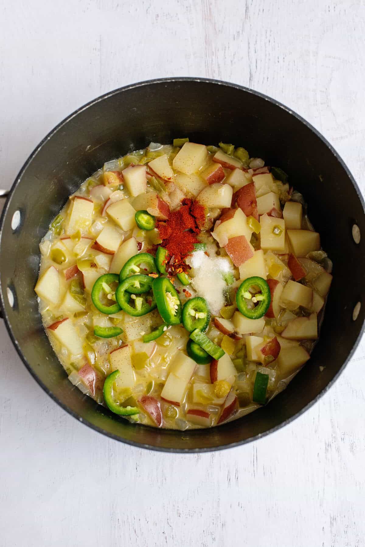 Jalapenos, red potatoes, and spices in a pan.