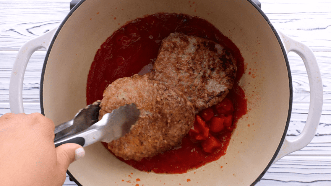 Place steaks on top of tomatoes.