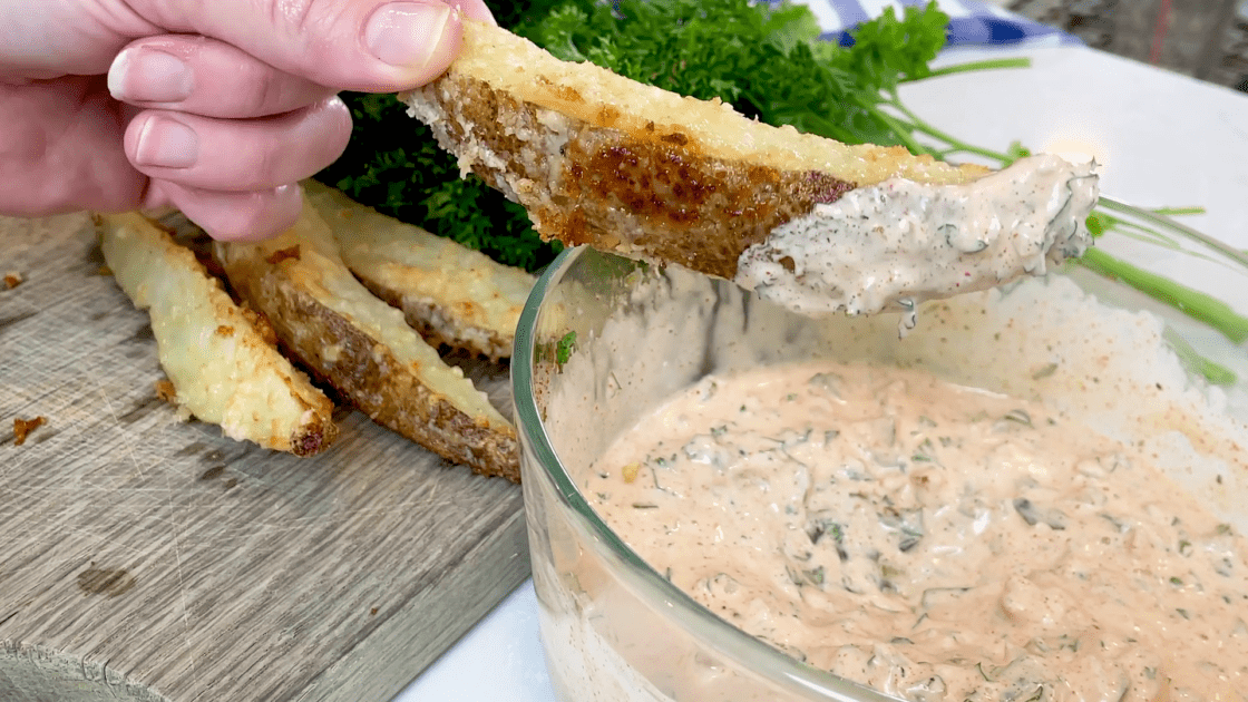 Dipping parmesan oven fries in tartar sauce.