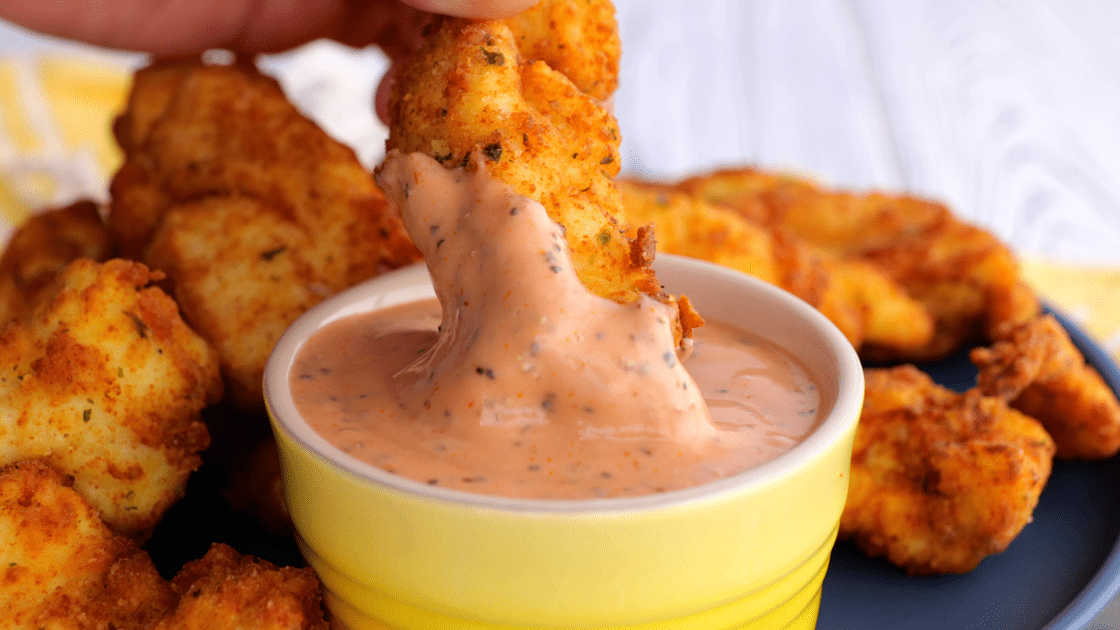 Dipping fried chicken.