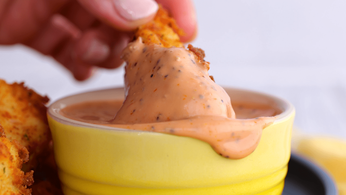 Dipping fried chicken in sauce.