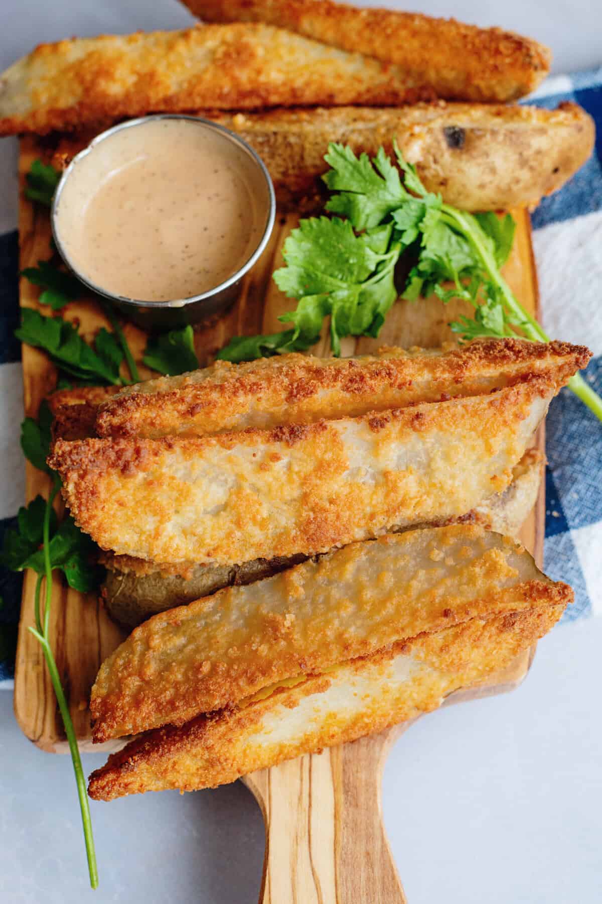 Parmesan oven fries on a serving tray with dipping sauce.