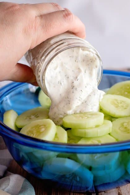 Pour dressing over cucumber slices in bowl.