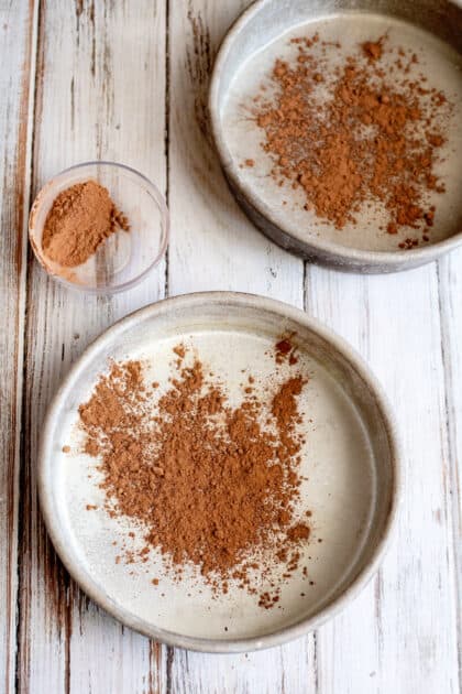 Sprinkle cocoa powder into greased cake pans.