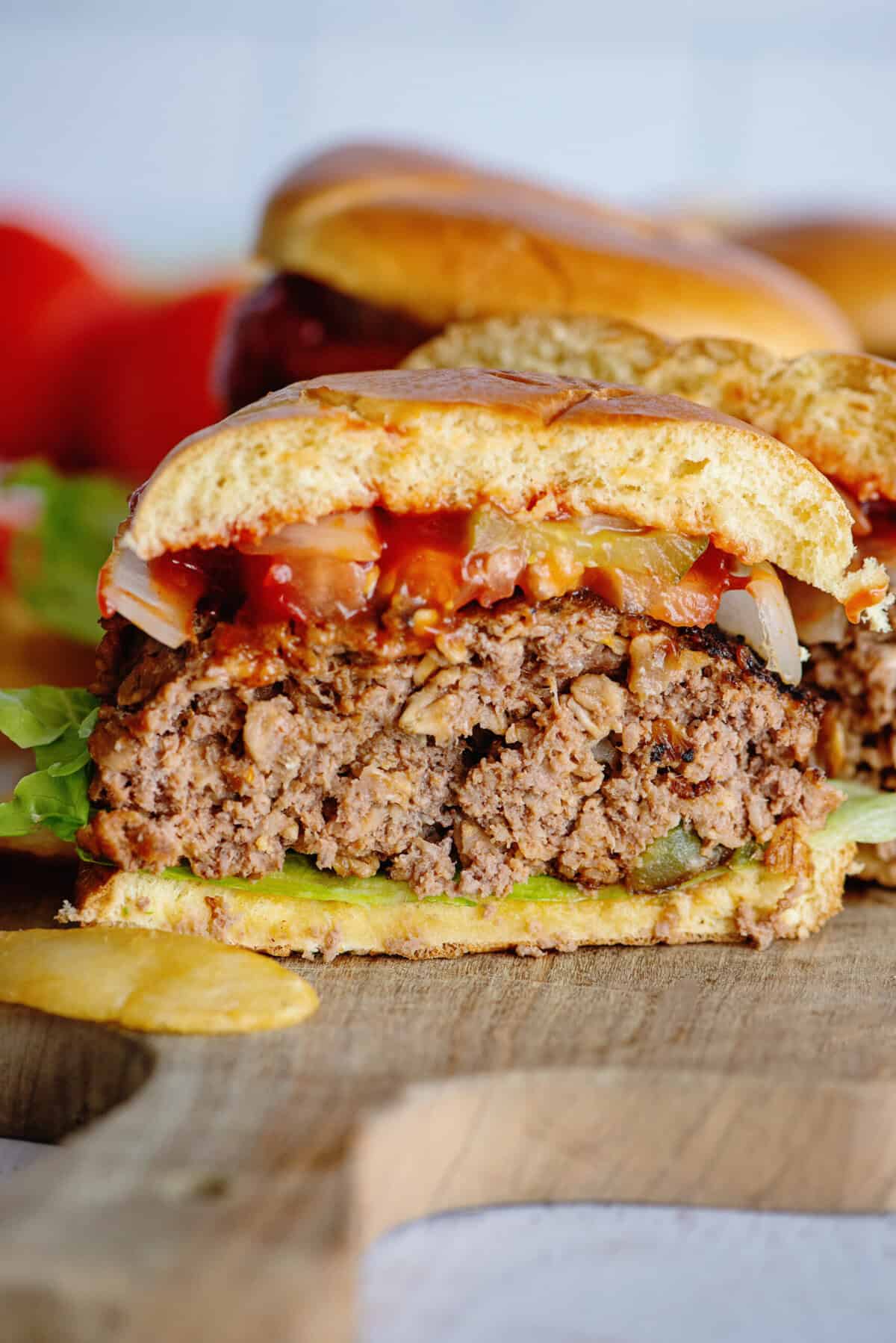 Sliced meatloaf burger showing layers of meatloaf patty, lettuce, tomato, onion, and ketchup.