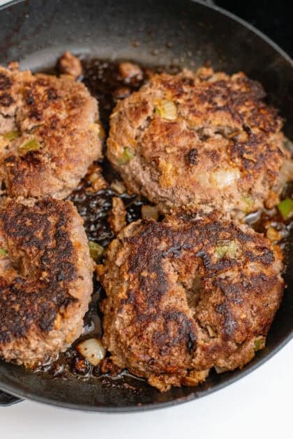 Seared meatloaf patties in a pan.
