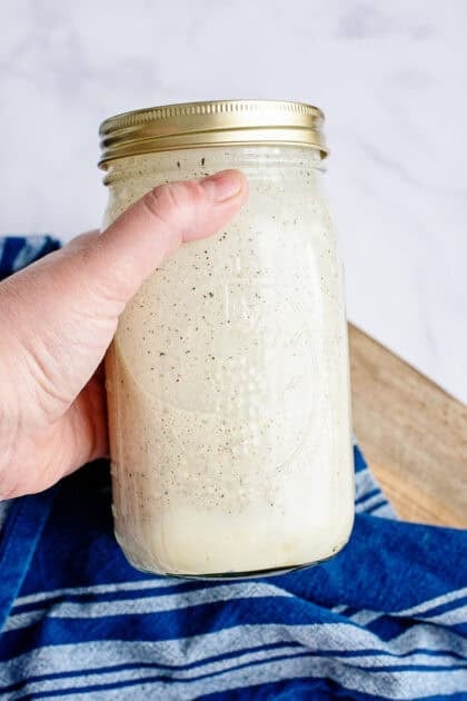A closed mason jar of Alabama white barbecue sauce.