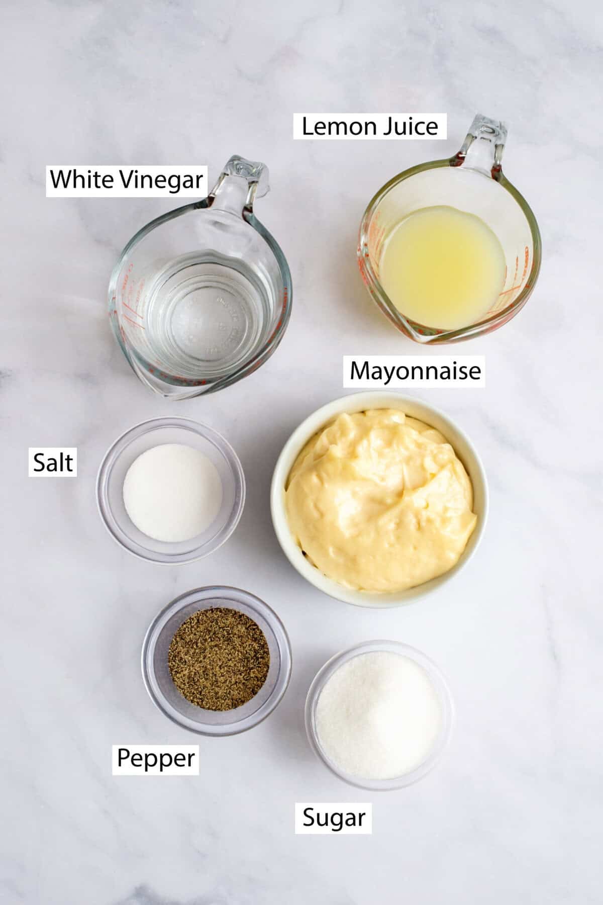 Ingredients for Alabama white barbecue sauce, featuring mayonnaise, black pepper, salt, lemon juice, white vinegar, and sugar.