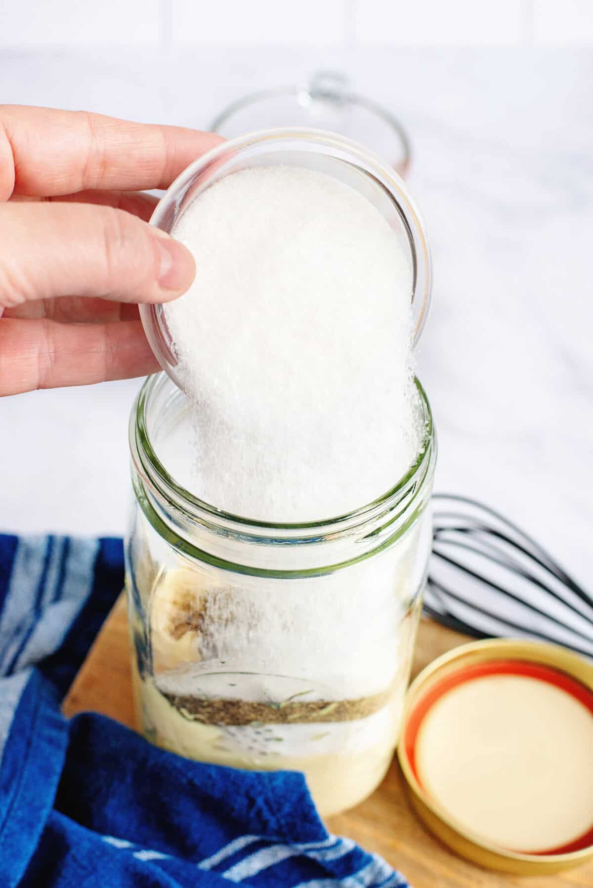 Adding salt to a mason jar.