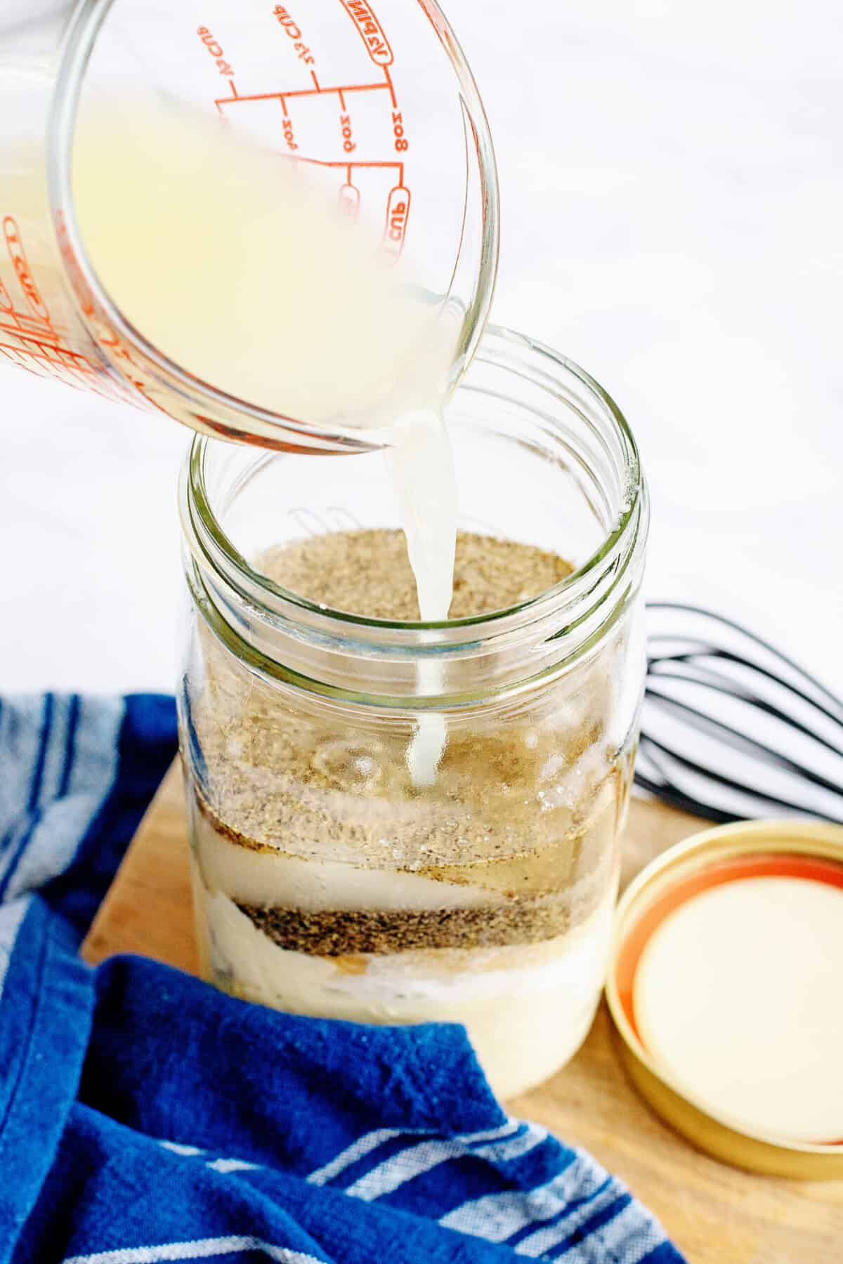 Adding lemon juice to a mason jar.