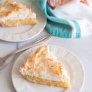 Two plates each with a slice of coconut meringue pie.