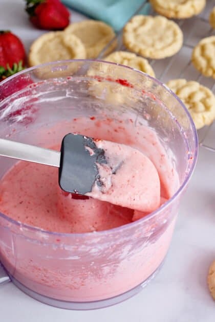 Test strawberry frosting consistency with spatula.