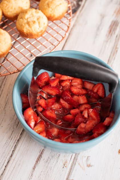 Mash strawberries roughly with pastry cutter.