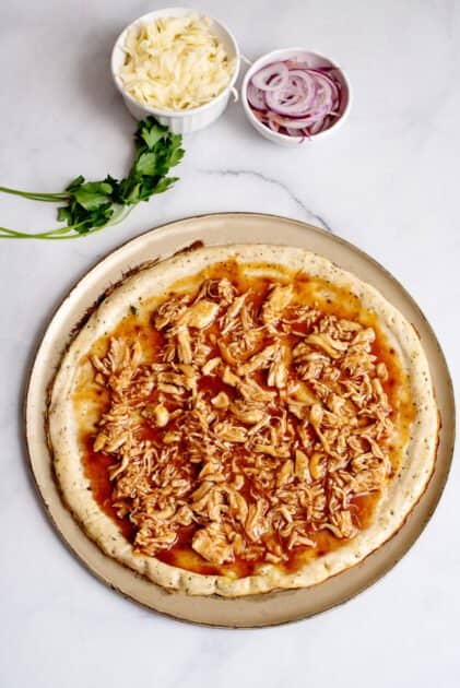 Spread saucy chicken over pizza crust.