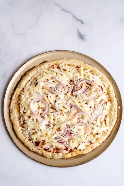Add onions and cheese and bake barbecue chicken pizza.